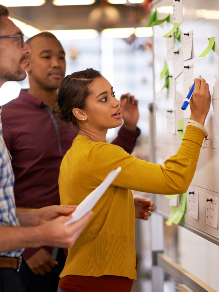 Workshop, bei dem eine Frau mit Postits einen Plan aufzeichnet